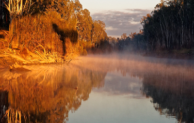 Early morning sunrise glow and rising mist over the Murray River in Corowa. 