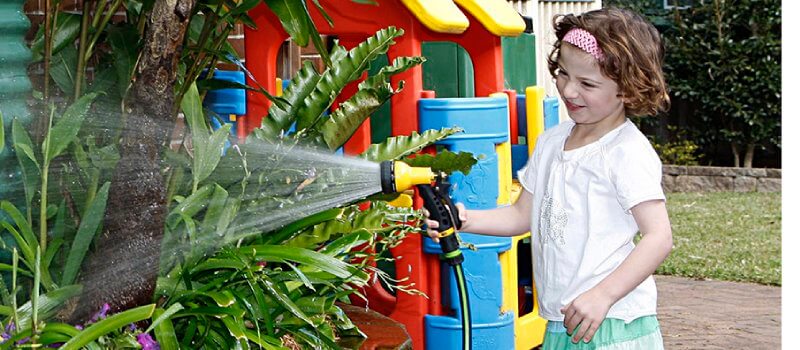 Girl watering gardening using water from a rainwater tank