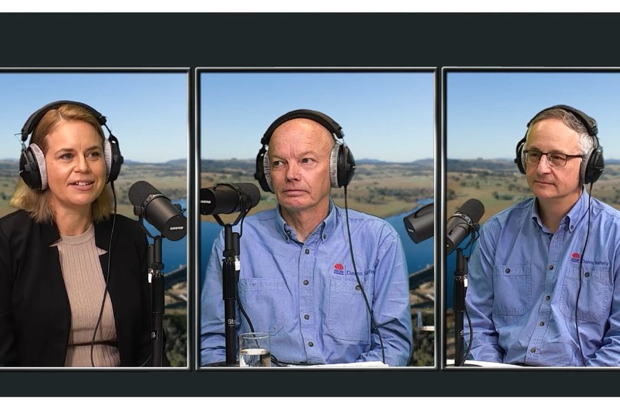 A woman and two men wearing headphones, speaking into microphones