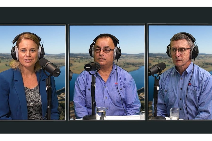 A woman and two men wearing headphones and speaking into microphones