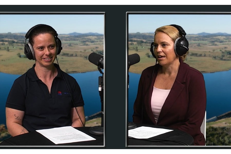 Two women wearing headphones, speaking into microphones