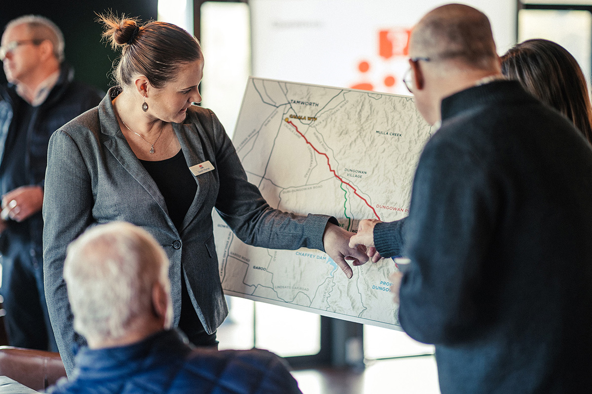 Engagement session with a woman pointing to a map