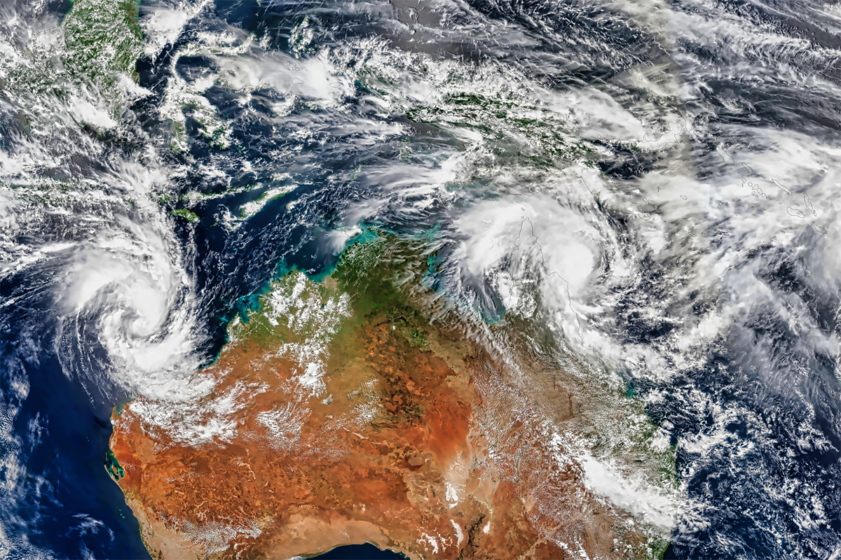 satellite image of  Australia with cloud formations over the northern half of the country