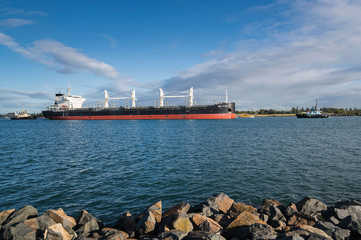 A large cargo ship is docked on a river. 