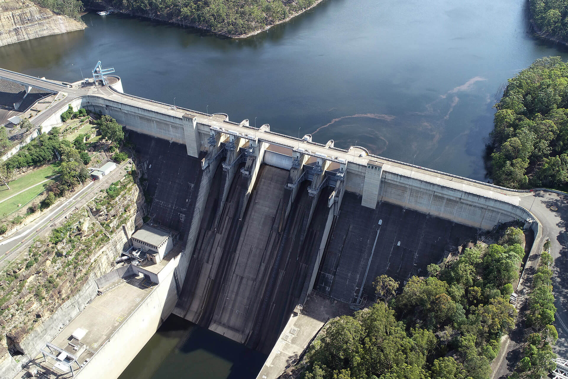 a tall grey dam wall holds back water at Warragamba dam