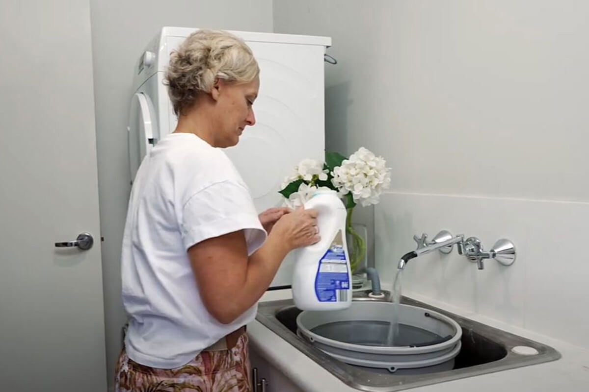 Woman standing over a laundry sink
